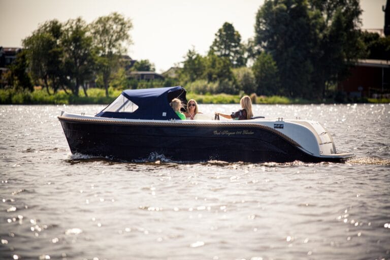 Oud Huijzer 616 Tender met blauwe romp en buiskap op het water.