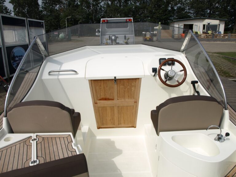 Stuurpositie, stoelen en gesloten cabinedeur van de Oud Huijzer 700 Cabin.