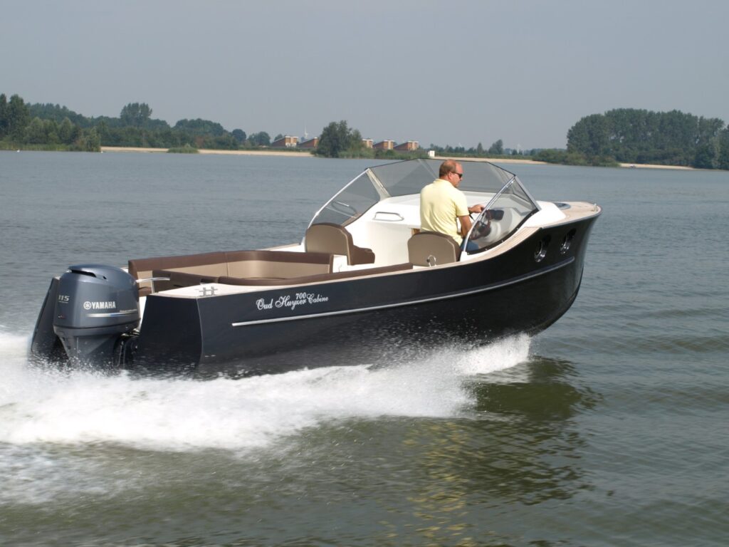 Oud Huijzer 700 Cabin varend met buitenboordmotor achter de spiegel.
