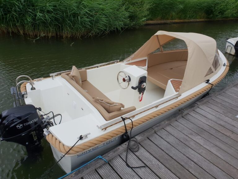 Kuip en stuurconsole van een Silver 495 met beige kussens aan de steiger.
