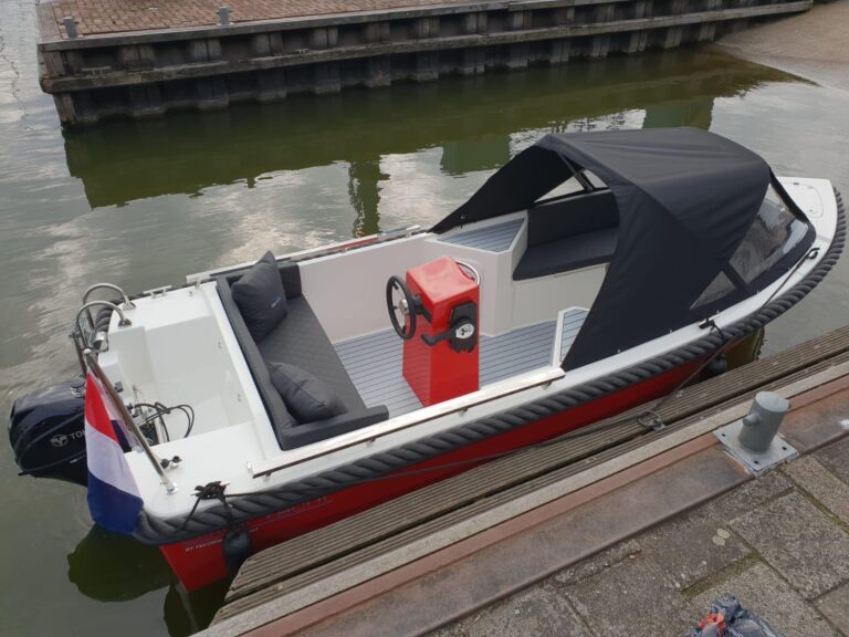 Rode Silver 495 met zwarte cabrioletkap en grijze kussens aan de steiger.