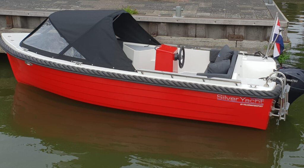 Zijaanzicht van een rode Silver 495 op het water.
