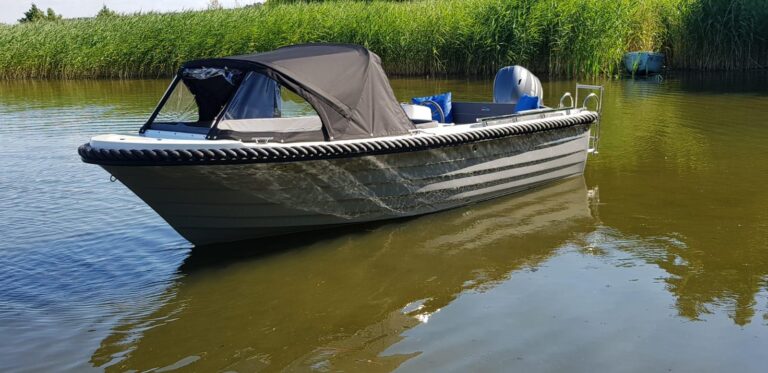 Silver 525 met donkere romp en opgezette cabrioletkap op het water.